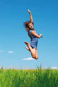 beautiful young long-haired woman jumping up background summer blue sky clouds